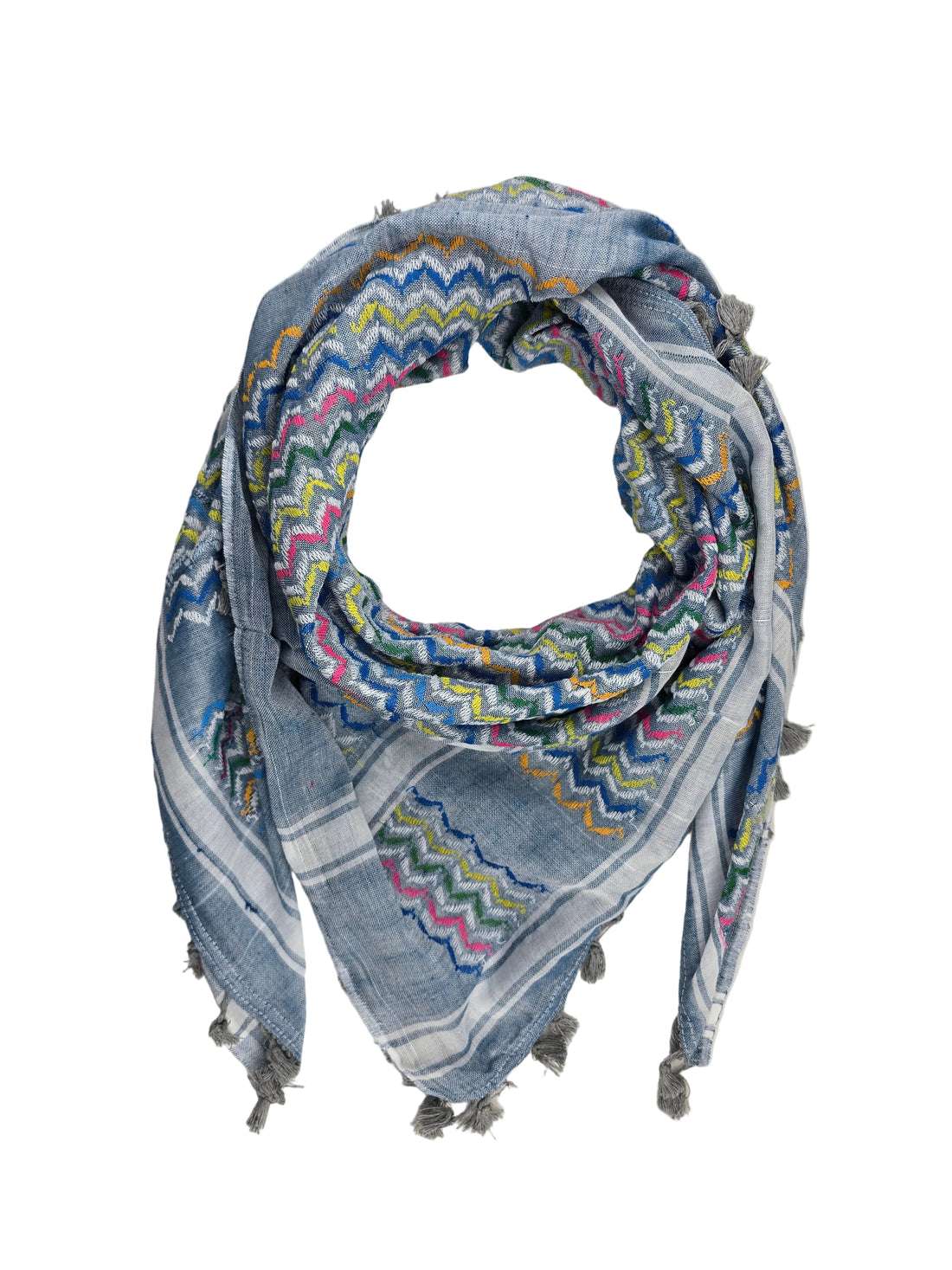 A square scarf with a blue-gray base and a colorful zigzag pattern in pink, yellow, green, and orange, finished with gray fringe tassels, laid flat on a white fabric background.