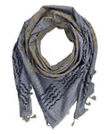 A gray woven scarf with yellow embroidered geometric patterns and frayed tassels, arranged in a loop on a white fabric background.